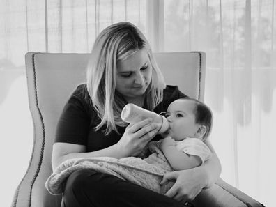 Anna Baker bottle feeds a baby.