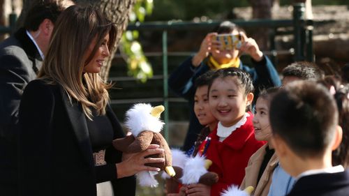 Mrs Trump gives a gift to Chinese children. (AAP)