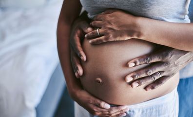 Cropped shot of an unrecognizable man and his wife touching her pregnant belly