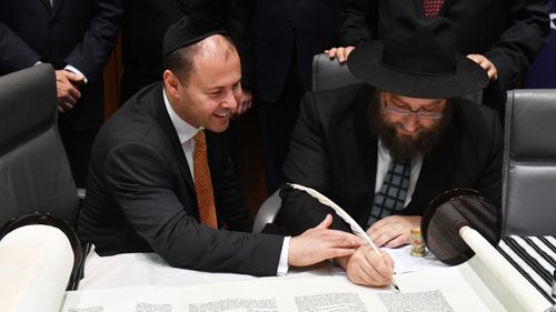 Josh Frydenberg and Rabbi Eli Gutnick at a ceremony to mark the completion of the first Torah to be written in Parliament House in Canberra, Thursday, October 19, 2017.