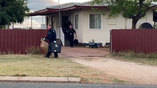 Forensics officers leave the family home.