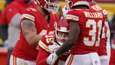 Kansas City Chiefs quarterback Patrick Mahomes is helped off the field by teammates.