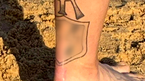 Um homem foi acusado de tatuagens nazistas que exibiu em uma praia em Newcastle.