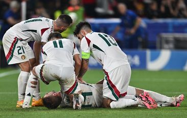 Barnabas Varga of Hungary lies on the ground and is assisted by teammates after a collision with goalkeeper Angus Gunn of Scotland.