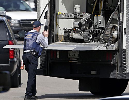 Hi-tech bomb disposal robots have been brought in to help the search for weapons inside the bomber's home. (AAP)