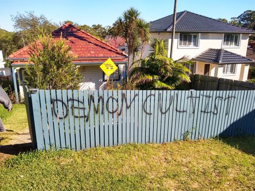 Le graffiti peint à la bombe sur la clôture de Nathalie Gits en réponse à son panneau climatique.