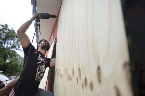 Cyber School Supply employee Christopher Rodriguez installs wood panels on windows in preparation in preparation for Hurricane Irma, in Carolina, Puerto Rico. (AP)