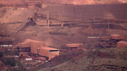 Iron ore stackers feed stockpiles at Tom Price Rio Tinto iron ore mine in the Pilbara Region in Western Australia.
