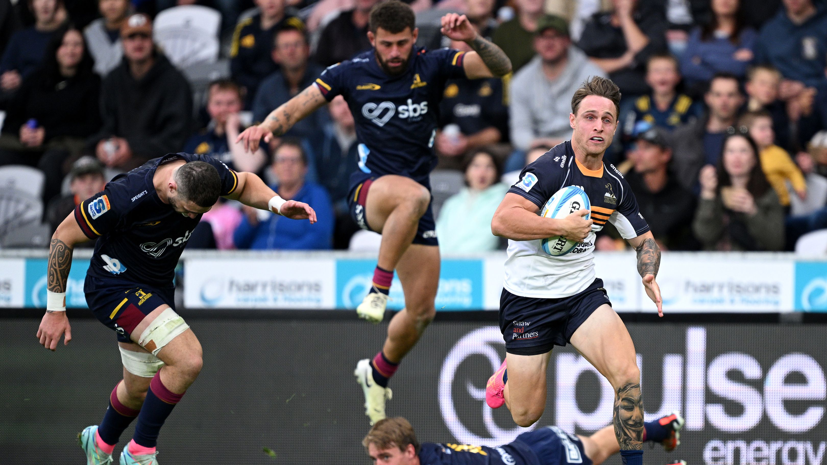 Corey Toole of the Brumbies charges towards the try line to score.