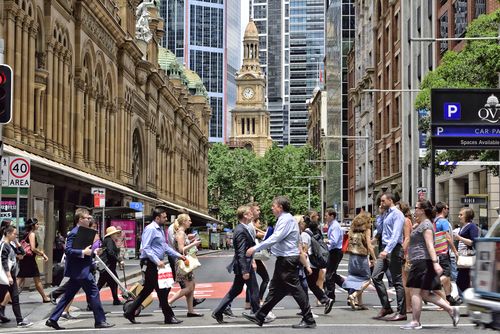 Sydney, Australia - 12 novembre 2015: La folla di persone attraversa la strada nel centro di Sydney. Punto di riferimento sullo sfondo, centro commerciale a sinistra.