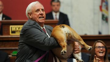 West Virginia Gov. Jim Justice holds up his dog Babydog&#x27;s rear end as a message to people who&#x27;ve doubted the state.