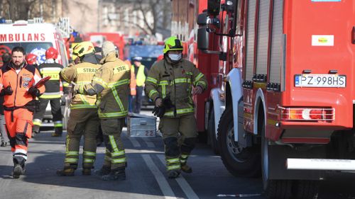 Firefighters and rescuers work at the scene of a building collapse. (AAP)