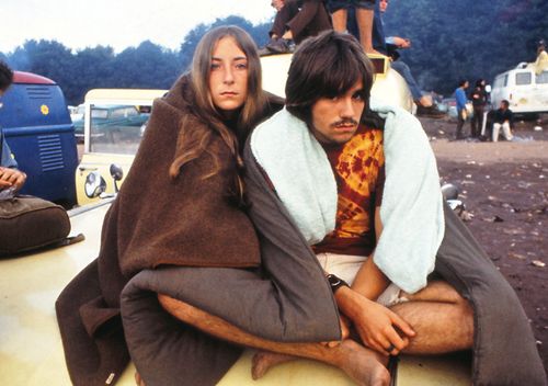 A young couple, sitting on a van, at the Woodstock Music Festival, New York