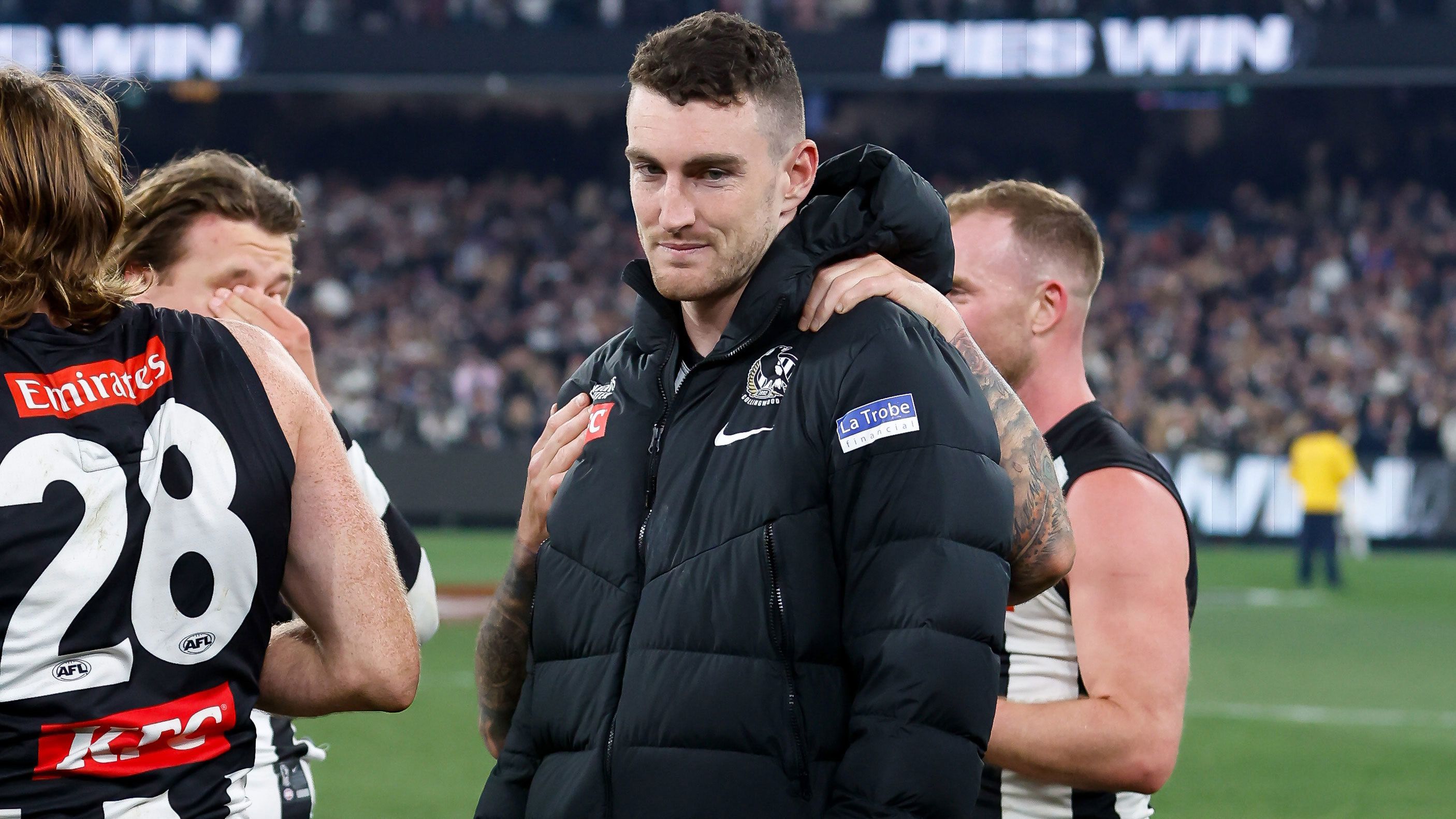 Daniel McStay of the Magpies is consoled by teammates after coming from the field early in their preliminary final win.