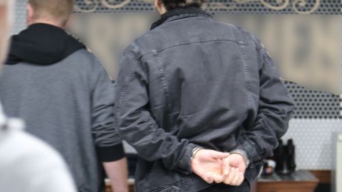 Police handcuff the accused inside a barber shop. 