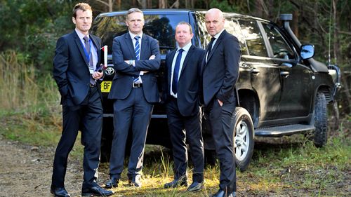 Detective Jubelin (far right) stands with other detectives while bushland is searched for signs of Tyrrell.