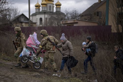 Ukrainian soldiers help a fleeing family crossing the Irpin river in the outskirts of Kyiv, Ukraine, Saturday, March 5, 2022.