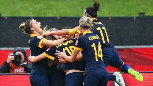 Kyah Simon of Australia (obscured) is mobbed by team mates in celebration after scoring. (Getty)
