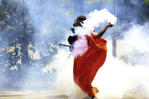 Un homme rejette une cartouche de gaz lacrymogène après qu'elle a été tirée par la police pour disperser des manifestants à Colombo, au Sri Lanka, le samedi 9 juillet 2022.