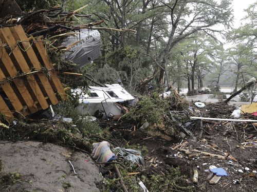 Damaged vehicles and debris are seen roped off near the banks of the Guadalupe River after flooding in Ingram, Texas.