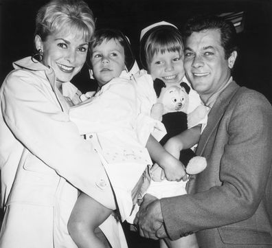 Aktor Amerika yang sudah menikah Janet Leigh dan Tony Curtis menggendong putri mereka Kelly (kanan), 5, dan Jamie Lee Curtis, 2, (kiri).