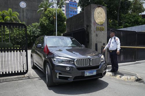 A car with diplomatic plates and Chinese flag leaves the Philippine Department of Foreign Affairs in Manila, Philippines on Aug. 7, 2023.
