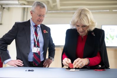Camilla, Duchess of Cornwall puts a poppy on her Remembrance cross at the Poppy Factory