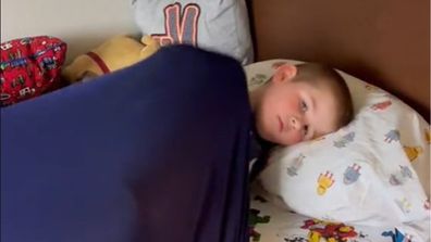Kid sleeping under sensory sheet