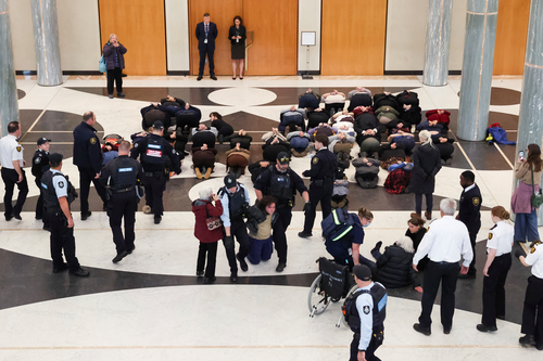 A segurança do Parlamento e a AFP removem manifestantes pró-Palestina do saguão de mármore do Parlamento em Canberra.