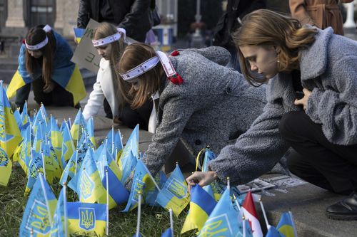 Ukrainian students, who lost relatives due to the Russia-Ukrainian war set flags in their memory on the memorial of fallen Ukrainian soldiers, while attending the reconstruction of a student-led protest campaign "Revolution on Granite" on Independence square in Kyiv, Ukraine, Tuesday, Oct. 17, 2023. 