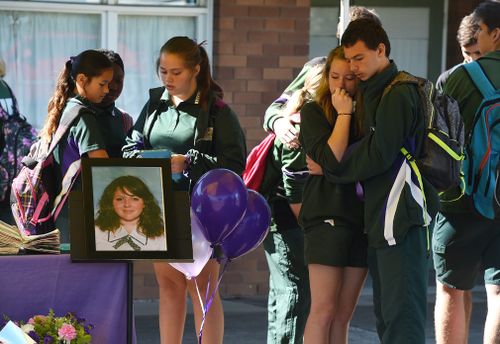 Friends comfort each other during the memorial service. (Image: AAP)