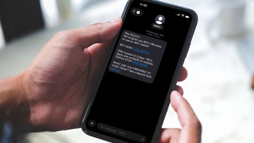 A phone showing a text from a gambling company to a customer.