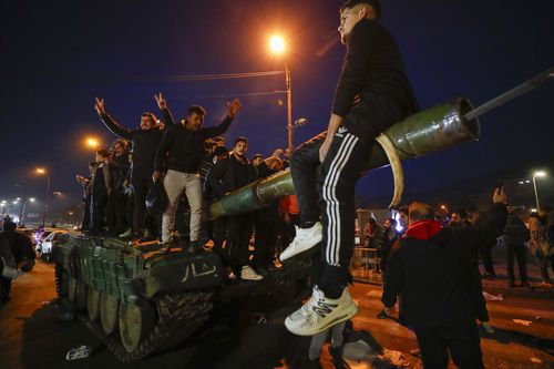 Syrians celebrate the arrival of opposition fighters in Damascus, Syria, Sunday, Dec. 8, 2024.