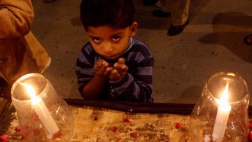  A boy from Pakistani political party Muttahida Qaumi Movement (MQM) prays as he attends a candle vigil in Karachi, Pakistan. (Getty)