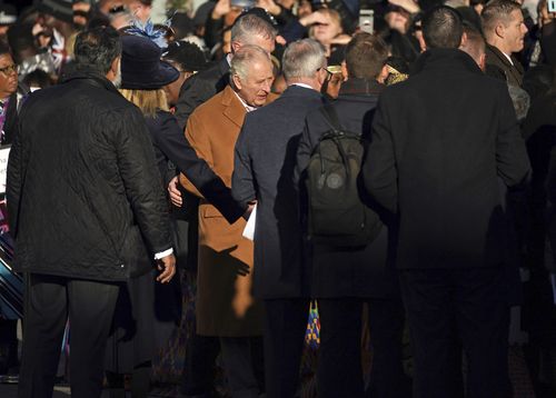 Close-protection officers usher Britain's King Charles III out of the way as he was meeting members of the public during a visit to Luton, England, Tuesday Dec. 6, 2022. 
