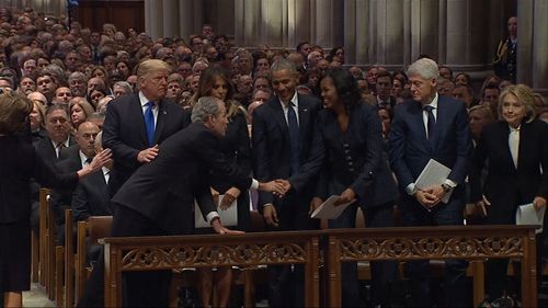 In a nod back to a previous joke, George Bush can be seen sliding a mint into the hand of Michelle Obama during their handshake.