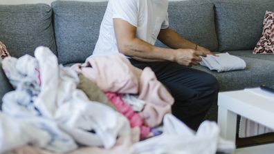 Man folding clothes at home.