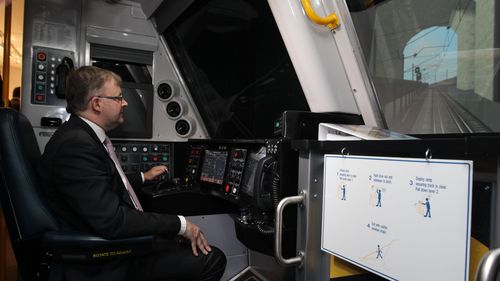 L'allora ministro delle Infrastrutture e dei trasporti Anthony Albanese guida un treno utilizzando un simulatore parcheggiato dietro l'Old Parliament House, a Canberra, lunedì 26 novembre 2012.