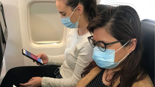 People wearing facemasks on a Qantas flight in 2020, during the early days of the covid-19 pandemic.