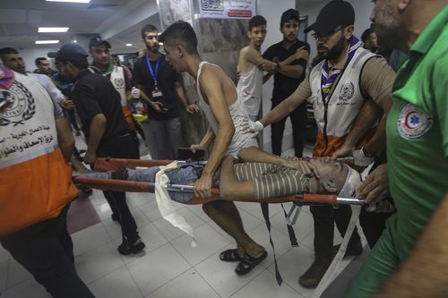 A wounded Palestinian is carried into the al-Shifa hospital