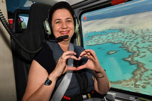 Ms Palaszczuk is seen making a heart gesture as she flies in a helicopter over Heart Reef on the Great Barrier Reef as part of the QLD election campaign yesterday. (AAP)
