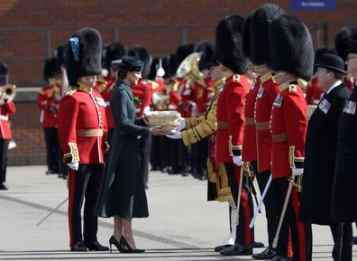 Prince William, Duke of Cambridge and Catherine, Duchess of Cambridge share a joke ahead of presenting baskets of shamrock to the Battalions Warrant Officers who will issue it out along the ranks during the 1st Battalion Irish Guards' St. Patrick's Day Parade at Mons Barracks on March 17, 2022 in Aldershot, England 