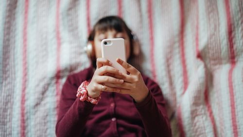 Girl successful furniture enjoying a bully euphony from smartphone app