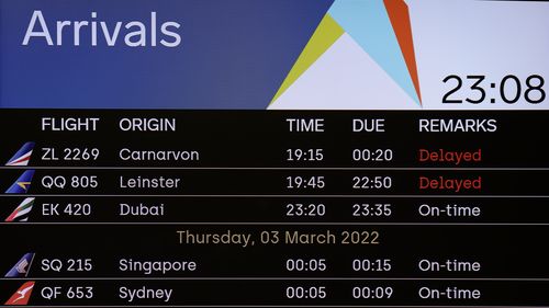 A flight arrivals board at the Perth International Airport Terminal showing the first flight in from Sydney.