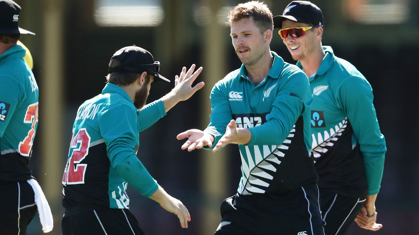 Lockie Ferguson of New Zealand celebrates with team mates after taking the wicket of David Warner 