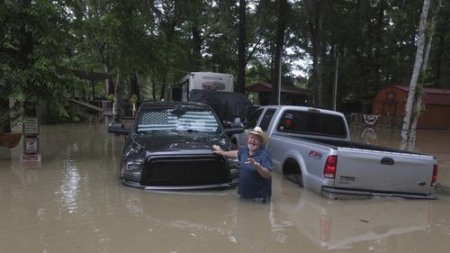 A man greets at Texas Parks & Wildlife Department game wardens as they arrive by boat to rescue residents from floodwaters in Liberty County, Texas.