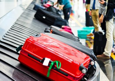 Luggages moving on airport conveyor belt. suitcase with ribbon