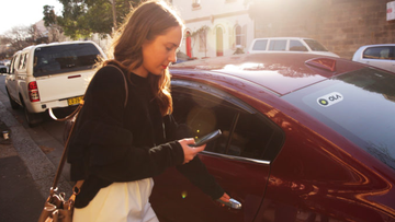 A woman using the Ola rideshare app.
