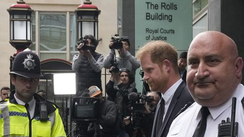 Prince Harry, second from right, escorted by security leaves the High Court after giving evidence in London in June, 2023.