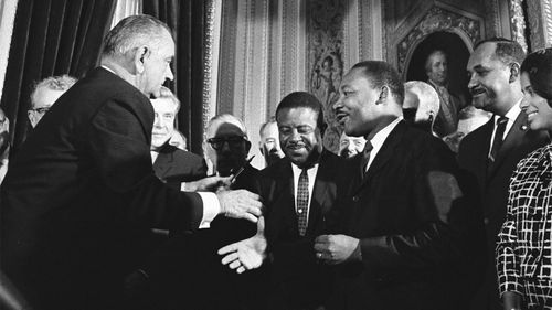 President Lyndon Johnson shakes Martin Luther King's hand after signing the Voting Rights Act of 1965.